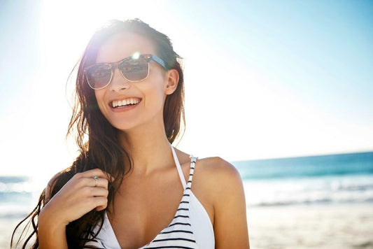 a girl on a beach wearing sunglasses